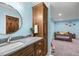 Stylish bathroom vanity with a gray marble countertop, dark wood cabinets, and a unique round mirror at 6331 County Road 32, Platteville, CO 80651