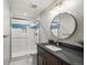 Updated bathroom with glass-enclosed shower, sleek vanity with a round mirror, and contemporary fixtures at 6331 County Road 32, Platteville, CO 80651