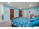 Bright bedroom with blue walls, ample natural light, and wood-trimmed doorways at 6331 County Road 32, Platteville, CO 80651