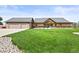 Inviting home featuring a charming porch, rock accents, and a lush green lawn at 6331 County Road 32, Platteville, CO 80651