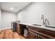 Modern laundry room with wood-look floors, stainless steel sink, and front-load washer and dryer at 6331 County Road 32, Platteville, CO 80651
