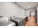 Well-equipped laundry room featuring modern appliances, wood-look floors, and ample counter space at 6331 County Road 32, Platteville, CO 80651