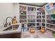 Spacious walk-in pantry with ample shelving, counter space and tile flooring for convenient storage and organization at 6331 County Road 32, Platteville, CO 80651