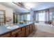 Bathroom with double vanity, soaking tub, and glass-enclosed shower at 15653 Split Creek Dr, Monument, CO 80132