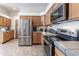 Well-lit kitchen with stainless steel appliances, light wood cabinets, and tile flooring at 15653 Split Creek Dr, Monument, CO 80132