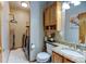 Small bathroom with toilet, sink with granite counters, cabinet, and adjacent laundry at 12135 Elizabeth St, Thornton, CO 80241