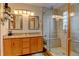 Updated bathroom with double sinks, granite countertops, and a glass-enclosed shower at 12135 Elizabeth St, Thornton, CO 80241