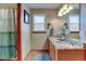 Bright bathroom featuring double sinks with granite countertops and a wood-look tile floor at 12135 Elizabeth St, Thornton, CO 80241