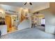 Open-concept living room with carpet and wood flooring, staircase, and unique decorations at 12135 Elizabeth St, Thornton, CO 80241