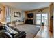 Inviting living room showcasing a leather sofa, neutral carpet, and sliding glass doors at 12135 Elizabeth St, Thornton, CO 80241