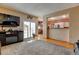 Open-concept living room with patio access, TV, and views into kitchen and dining areas at 12135 Elizabeth St, Thornton, CO 80241