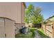 Backyard with mature tree, privacy fence and air conditioner at 2035 Overland Dr, Brighton, CO 80601