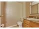 Neutral half bath with beige walls and a sink with wooden cabinet, perfect for guests at 2035 Overland Dr, Brighton, CO 80601