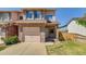 Charming two-story townhome with brick facade, attached garage, and inviting front yard at 2035 Overland Dr, Brighton, CO 80601