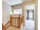 Hallway with wood banister and an open view into a bedroom with natural light at 2035 Overland Dr, Brighton, CO 80601
