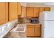 Kitchen featuring wooden cabinets, tile backsplash, stainless steel sink, and white refrigerator at 2035 Overland Dr, Brighton, CO 80601