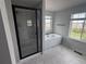 Bathroom featuring a glass-enclosed shower, a soaking tub, and views from the two windows at 4284 Ridgewalk Pt, Castle Rock, CO 80108