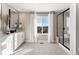 Bright bathroom with double sink vanity, framed mirror, white tile floors and a walk-in shower at 4284 Ridgewalk Pt, Castle Rock, CO 80108
