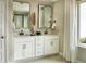 Stylish bathroom featuring double vanity, framed mirrors, white cabinets and stone countertops at 4284 Ridgewalk Pt, Castle Rock, CO 80108