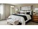 A main bedroom featuring a black canopy bed, white bedding, dark green throw, and a bench at 4284 Ridgewalk Pt, Castle Rock, CO 80108