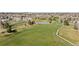 Scenic view of the golf course, with lush green fairways, mature trees, a pond, and residential homes in the distance at 11 Canongate Ln, Highlands Ranch, CO 80130