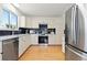 Bright kitchen with white cabinets, stainless steel appliances, and hardwood floors at 11 Canongate Ln, Highlands Ranch, CO 80130