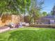 Serene backyard showcasing a fire pit, comfortable seating, mature trees, and lush green lawn at 6664 Gray St, Arvada, CO 80003