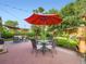 Outdoor patio with a red umbrella, lush greenery, and comfortable seating, perfect for dining or relaxing at 6664 Gray St, Arvada, CO 80003