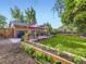 Expansive backyard with garden beds, a spacious lawn, and a charming patio, ideal for outdoor living at 6664 Gray St, Arvada, CO 80003