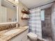 Charming bathroom with granite vanity, tiled shower, and stylish shelving for organized storage at 6664 Gray St, Arvada, CO 80003