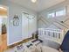 Bright Bedroom featuring a crib, reading chair, and ample storage at 6664 Gray St, Arvada, CO 80003