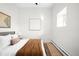 Bedroom with sleek white walls, stylish decor, cozy bed, and ample natural light at 2351 Federal Blvd # 102, Denver, CO 80211