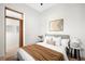 Bright bedroom features a comfortable bed with neutral linens, stylish decor, and wood trim doorway at 2351 Federal Blvd # 102, Denver, CO 80211