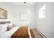 Serene bedroom features neutral decor, textured bedding, a small window, and minimalist artwork at 2351 Federal Blvd # 102, Denver, CO 80211