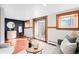 Bright living room with terra cotta floors, natural wood trim, neutral decor, and an exterior door at 2351 Federal Blvd # 102, Denver, CO 80211