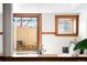 Cozy space featuring an outdoor view, access to patio, and hardwood trim details at 2351 Federal Blvd # 102, Denver, CO 80211