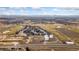 Overview of a residential community's placement amongst open land and growing construction at 2405 Horse Shoe Cir, Fort Lupton, CO 80621