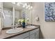 Bathroom featuring double sinks, a large mirror, and a walk-in shower at 2405 Horse Shoe Cir, Fort Lupton, CO 80621