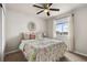Bright and airy bedroom with floral bedding, decorative mirror, and a window with natural light at 2405 Horse Shoe Cir, Fort Lupton, CO 80621