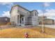 Charming two-story gray home with a three-car garage and a well-manicured lawn at 2405 Horse Shoe Cir, Fort Lupton, CO 80621