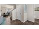 Bright hallway with wood floors, white trim, and a view into the living room at 2405 Horse Shoe Cir, Fort Lupton, CO 80621