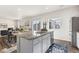 Open concept kitchen island and dining area featuring modern finishes and natural light from sliding glass doors at 2405 Horse Shoe Cir, Fort Lupton, CO 80621
