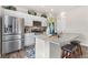Well-lit kitchen featuring stainless steel appliances, white cabinets, and an island with barstool seating at 2405 Horse Shoe Cir, Fort Lupton, CO 80621