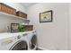 Functional laundry room with front load washer and dryer and extra storage baskets at 2405 Horse Shoe Cir, Fort Lupton, CO 80621