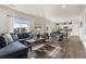 Spacious living room with a large sectional sofa, wood floors, and plenty of natural light at 2405 Horse Shoe Cir, Fort Lupton, CO 80621