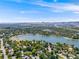 Stunning aerial view showcases a large lake surrounded by lush greenery and mountains in the distance under a blue sky at 1810 Youngfield Ct # A, Golden, CO 80401