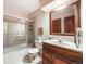 Comfortable bathroom features a vanity with wood cabinets, large mirror, tile floors, and shower-tub combo at 1810 Youngfield Ct # A, Golden, CO 80401