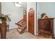 Hallway featuring carpeted stairs, hardwood floors, a decorative cabinet, and neutral wall paint at 1810 Youngfield Ct # A, Golden, CO 80401