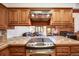 View of kitchen featuring wooden cabinets, tile countertops, stainless steel appliances, and view of the living room at 1810 Youngfield Ct # A, Golden, CO 80401