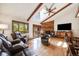 Bright living room with vaulted ceilings, exposed beams, a brick fireplace, and comfortable leather seating at 1810 Youngfield Ct # A, Golden, CO 80401